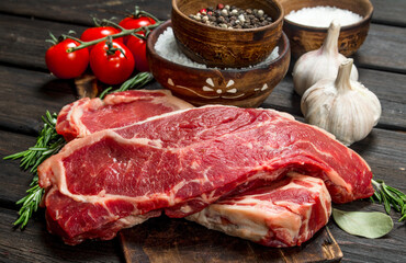 Raw beef steaks with salt and spices.