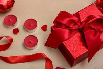 Composition with candles and gift box on color background, closeup. Valentine's Day celebration