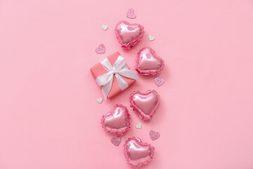Composition with beautiful balloons and gift box on pink background. Valentine's Day celebration