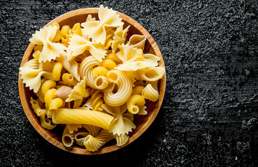 Different types of dry pasta in a bowl.