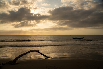 Sunset on a Caribbean beach in Barranquilla with a fisherman's boat anchored.