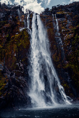 Fototapeta na wymiar Closeup Of Mountain Waterfall Cascading Into Water at Sterling Falls, Milford Sound in Fiordland National Park, New Zealand 2