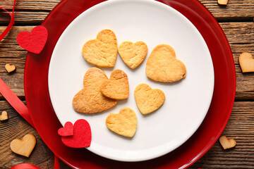 Composition with plate of tasty heart shaped cookies and decor on wooden background, closeup. Valentines Day celebration