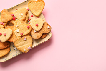 Plate with sweet heart shaped cookies and sprinkles on pink background. Valentines Day celebration