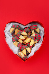 Box with tasty fortune cookies on red background. Valentine's Day celebration