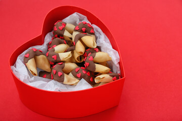 Box with tasty fortune cookies on red background. Valentine's Day celebration