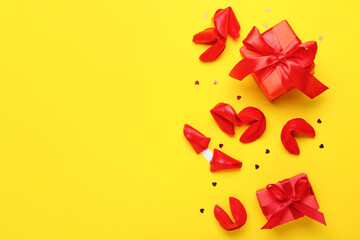 Composition with tasty fortune cookies and gift boxes on yellow background. Valentine's Day celebration