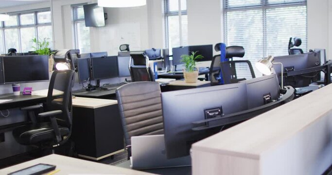 General view of empty modern office with multiple computers, slow motion
