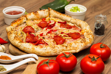 Sausage and vegetable pizza served on round wooden board
