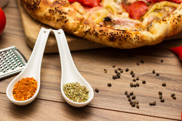 Sausage and vegetable pizza served on round wooden board