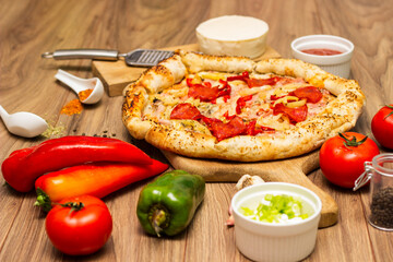 Sausage and vegetable pizza served on round wooden board