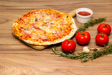 Freshly baked pizza with ham, tomato, and cheese