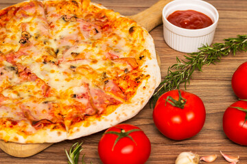 Freshly baked pizza with ham, tomato, and cheese