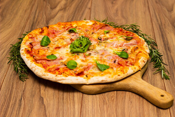 Freshly baked pizza with ham, tomato, and cheese