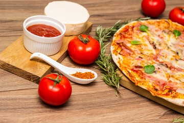 Freshly baked pizza with ham, tomato, and cheese