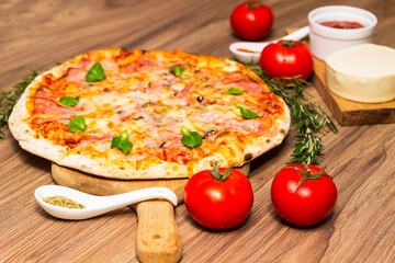Freshly baked pizza with ham, tomato, and cheese