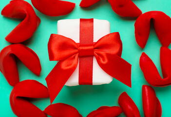 Red fortune cookies with gift on green background, closeup. Valentine's Day celebration