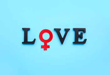 Word LOVE with symbol of woman on blue background. Valentine's Day celebration