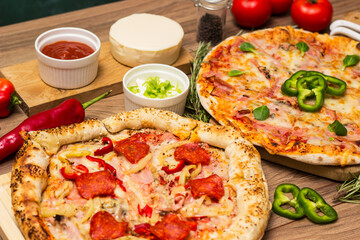 Two different pizza with ingredients on rustic background. Pepperoni pizza and pizza Capricciosa with mozzarella cheese, ham, tomato sauce, salami, mushroom, pepper, spices and fresh basil