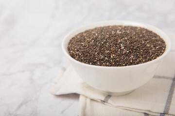 Chia seeds in bowls on a white marble background. SUPERFOOD and antioxidant. Healthy food concept. Gluten free. Copy space.