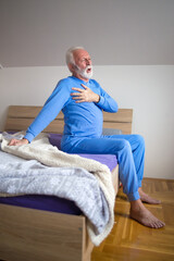 Senior man in pajamas waking up with chest pain in the morning	