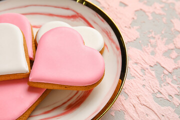Plate with heart shaped cookies on pink grunge background, closeup. Valentines Day celebration