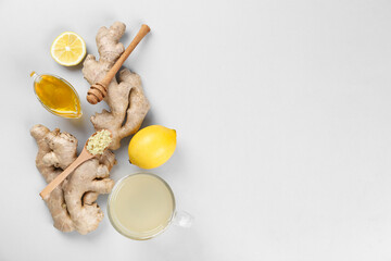 Ginger roots, cup of tea, lemon and honey on grey background