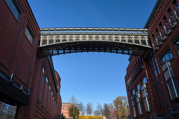 Naklejka premium A metal bridge and a brick walls of a historic brewery