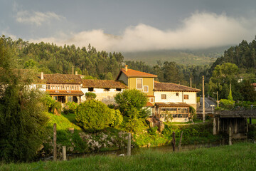 Fototapeta na wymiar View of an Asturian little village of the Picos de Europa mountains during sunset after the rain