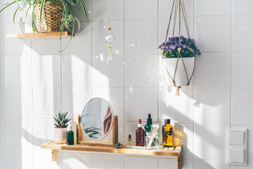 Hanging crystal sun catcher against white tile wall in modern eco friendly bathroom. Shadows on the...