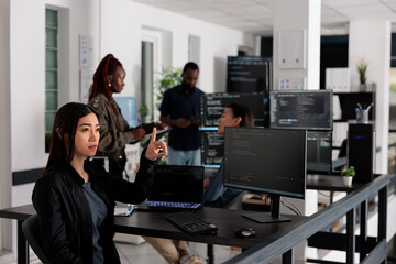 Asian web developer working with hologram and coding language in programming software company. Programmer analyzing holographic html code and augmented reality to develop new server interface.