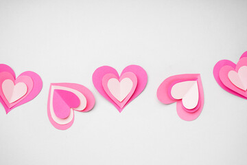Composition with paper hearts on light background. Valentines Day celebration