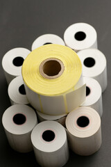 A pile of thermal label paper.
Roll of blank thermal paper for cash register machine isolated over black background close-up.Roll of cash register tape isolated on soft gray background.High resolution