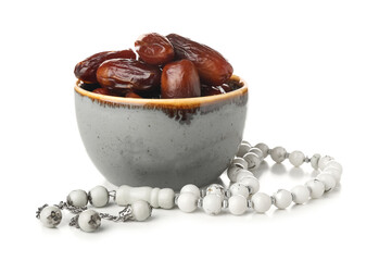 Bowl with dried dates and prayer beads for Ramadan on white background