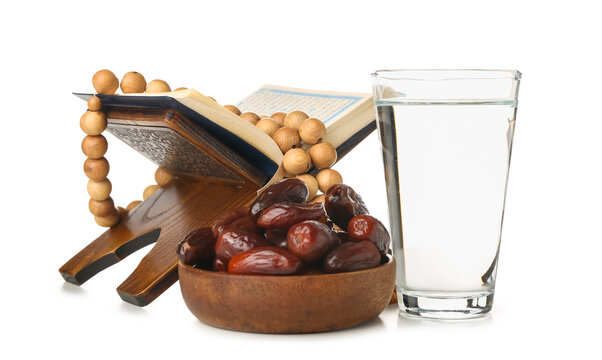 Bowl With Dates, Koran, Prayer Beads And Glass Of Water For Ramadan On White Background