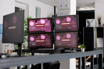 Software company having computers displaying critical error message showing on screen, dealing with hacking threat and pc malware. Empty desk with multiple monitors flashing security breach alert.