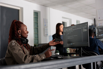 Smiling software developer programming server code algorithm on computer, typing sever data in big data office. Database engineer working on new user interface with online system to create algorithm.