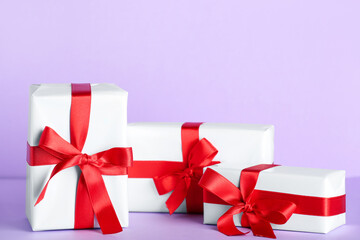 Gift boxes with beautiful bows on lilac background. Valentine's Day celebration