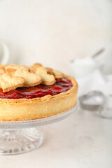 Stand with sweet strawberry pie and cookie hearts for Valentine's day on white table