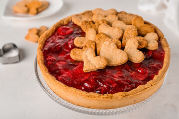 Stand with sweet strawberry pie and cookie hearts for Valentine's day on white table