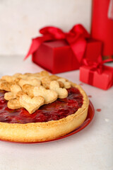 Plate with sweet strawberry pie, cookie hearts and gifts for Valentine's day on white table