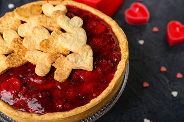 Stand with sweet strawberry pie, cookie hearts and heart-shaped candles for Valentine's day on dark background