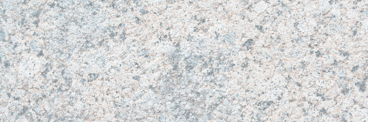 Granite texture. Natural gray granite with a grainy pattern. Stone background. Solid rough surface of rock. Durable construction and decoration material. Close-up.
