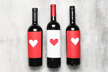 Bottles of wine with paper hearts on grey table. Valentine's Day celebration