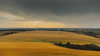 Aerial view of wind turbine. Windmills at harvest time, fields from above.