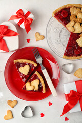 Red plate with pieces of sweet strawberry pie, cookie hearts and gifts for Valentine's day on white background