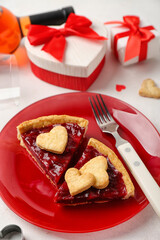 Red plate with pieces of sweet strawberry pie, cookie hearts and gifts for Valentine's day on white background