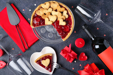 Composition with sweet strawberry pie, cookie hearts, gifts, bottle of wine, glasses and romantic candles for Valentine's day on black background