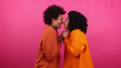 Girlfriend leaving lipstick mark on the face of a guy. Close-up view of young people kissing on a romantic Valentine's date. High quality 4k footage