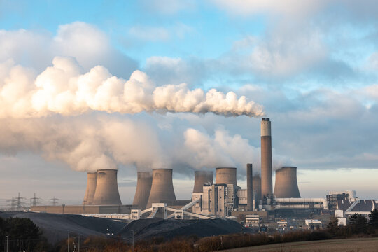 Coal power station with smoke coming out of cooling towers and chimney